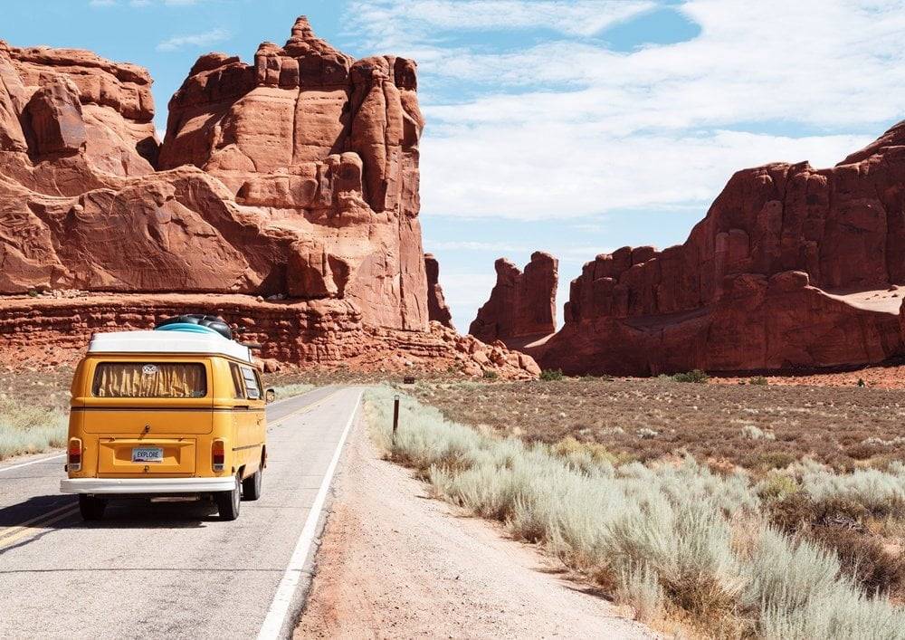 Van on a road surrounded by Canyons